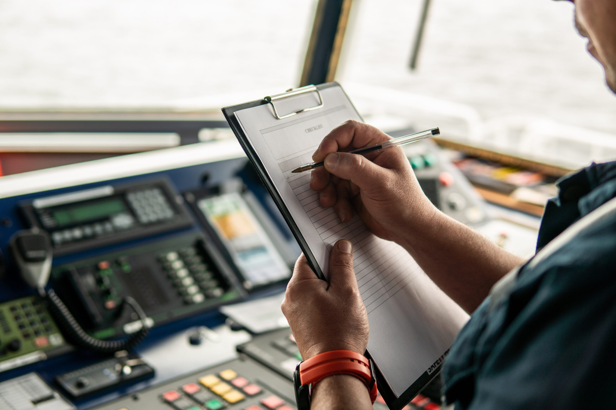 Marine navigational officer or chief mate on navigation watch on ship or vessel. He fills up checklist. Ship routine paperwork