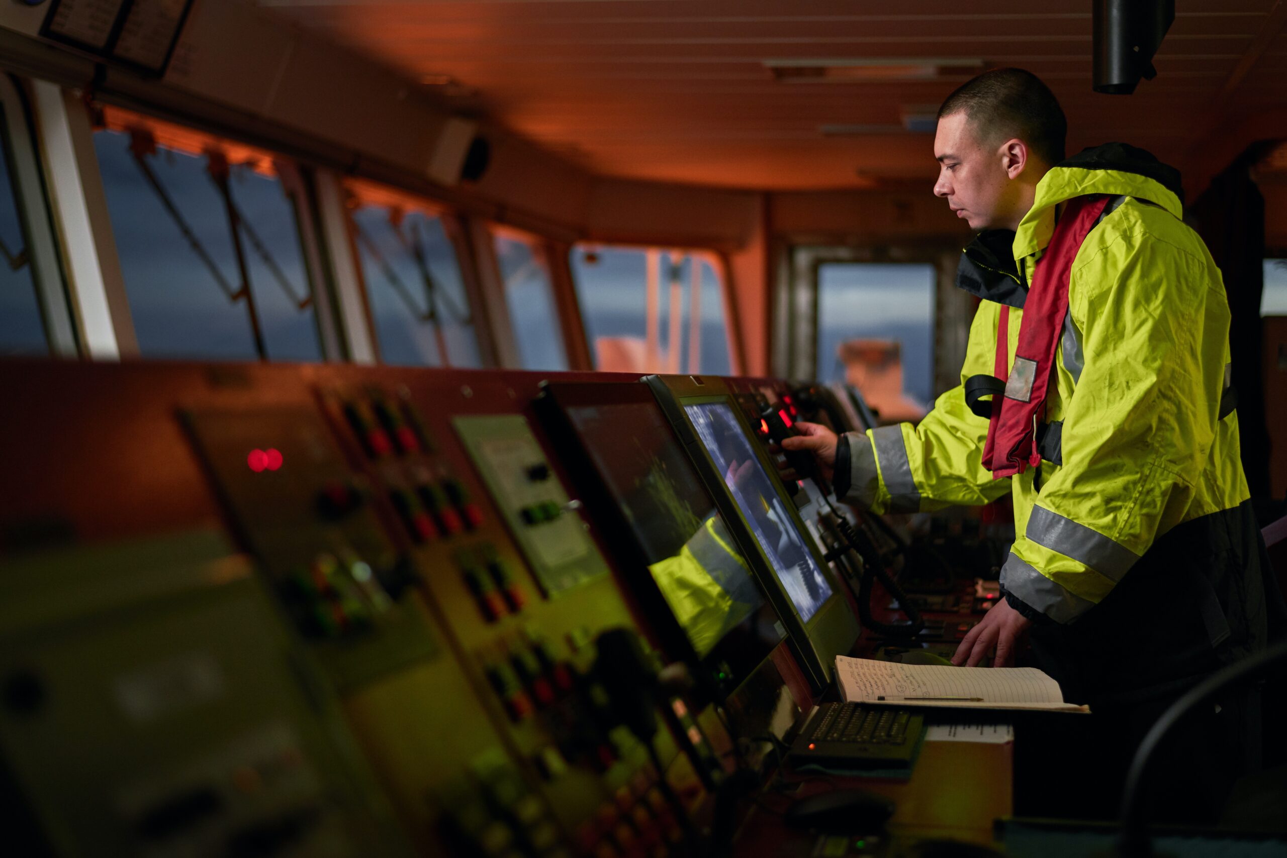 Navigator. pilot, captain as pat of ship crew performing daily duties with VHF radio, binoculars, logbook, standing nearby to ECDIS and radar station on board of modern ship with high quality navigation equipment on the bridge. Great design for navigation, safety of shipping, cargo carriage puproses.